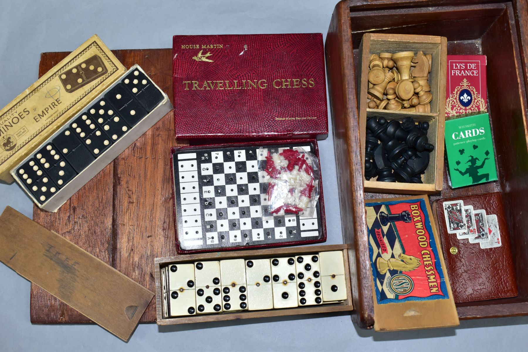 A WOODEN BOX CONTAINING A BOXED SET OF TSL BOXWOOD CHESSMEN, a boxed set of Crystalate dominoes,