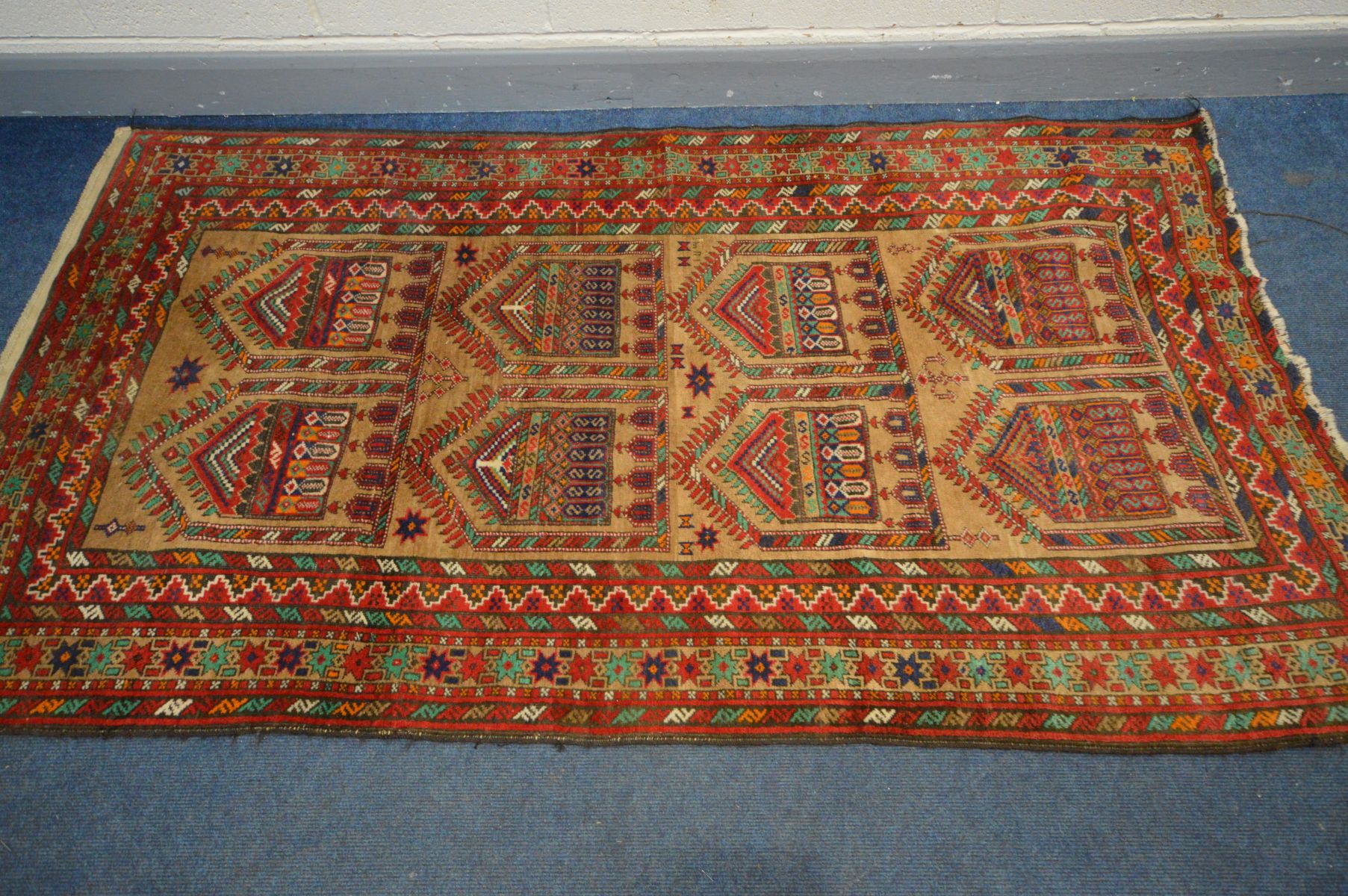 AN INDIAN RUG, russet and red field, and multistap border, 238cm x 128cm