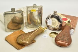 A BOX CONTAINING TWO BLACK POWDER FLASKS, decorated and three drinking hip flasks, two are boxed