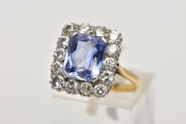 A MID TO LATE 20TH CENTURY SAPPHIRE AND DIAMOND CLUSTER RING, an emerald cut purplish blue sapphire,