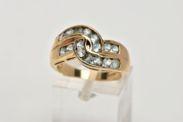 A 9CT GOLD AQUAMARINE DRESS RING, of a crossover design, set with two rows of channel set circular