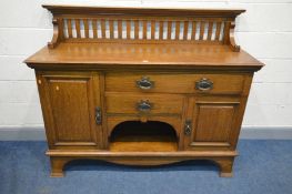 MAPLE AND CO, AN ARTS AND CRAFTS OAK SIDEBOARD, with a raised spindled back, above an arrangement of