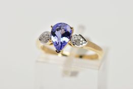 A 9CT GOLD TANZANITE AND DIAMOND RING, the central pear shape tanzanite in a three claw setting,