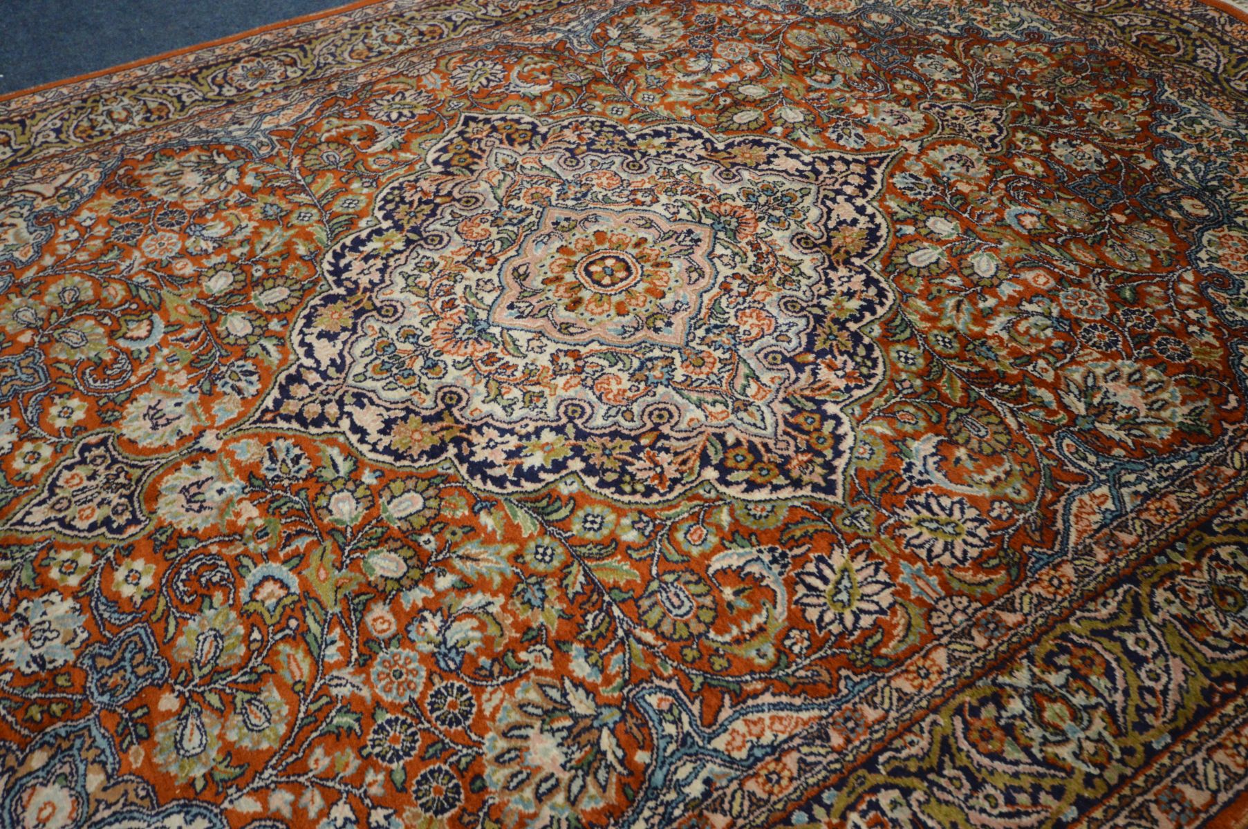 A KASHMIRI SILK RUG, scrolling foliate design on a red field, 182cm x 125cm, a woollen cream - Image 3 of 6