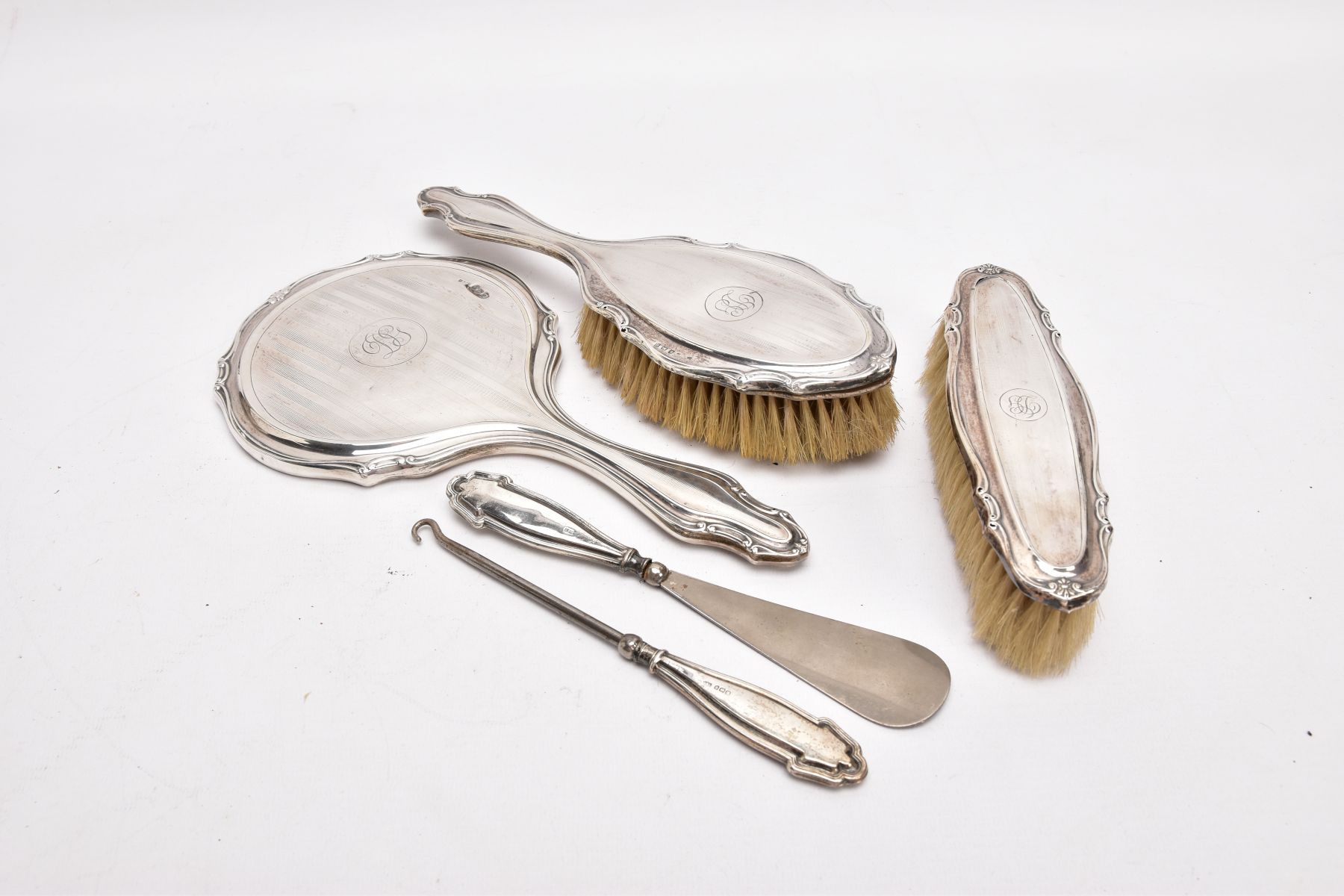 A THREE-PIECE SILVER VANITY SET A BUTTON HOOK AND A SHOEHORN, the vanity set comprising of a