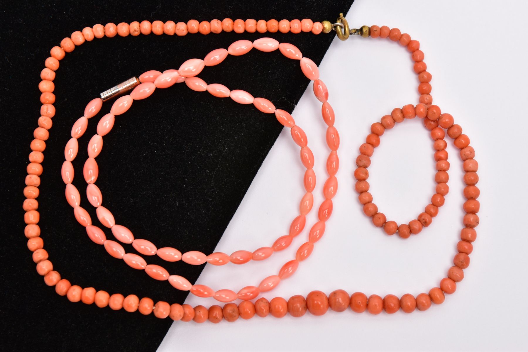 TWO CORAL BEAD NECKLACES, the first a row of graduated spherical coral beads measuring approximately