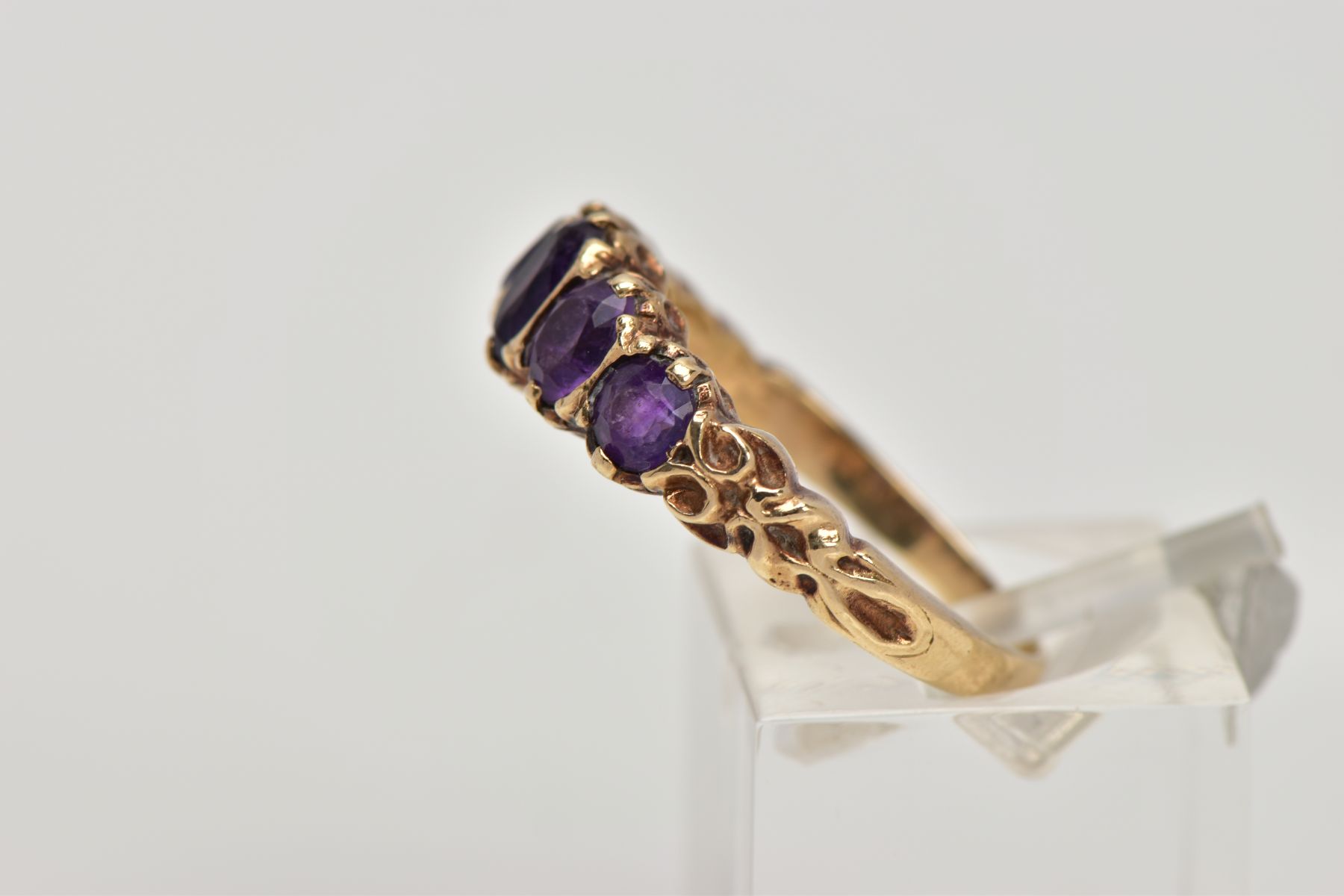 A 9CT GOLD FIVE STONE AMETYHST RING, designed with a row of five graduated oval cut amethyst, scroll - Image 2 of 4