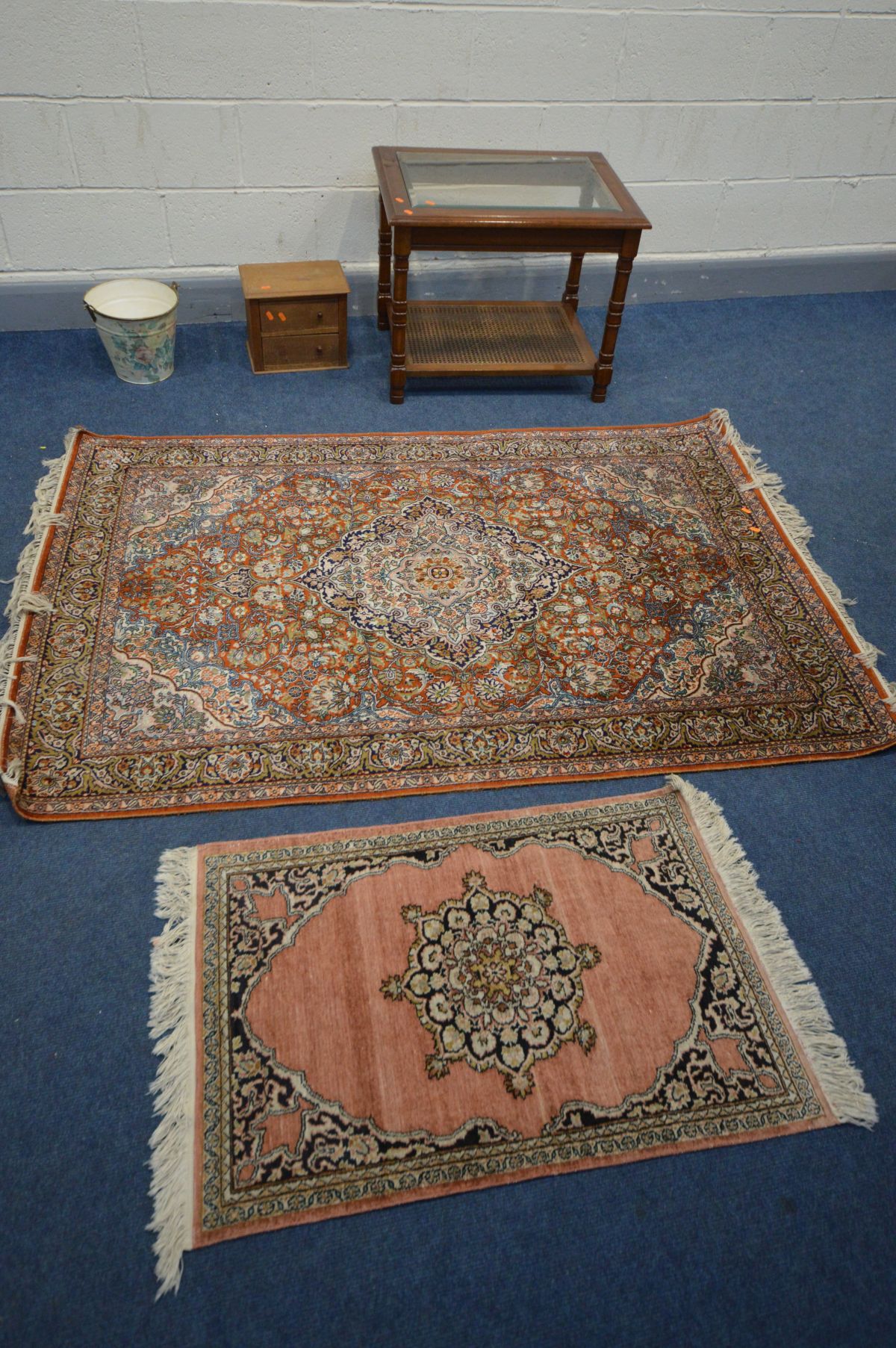 A KASHMIRI SILK RUG, scrolling foliate design on a red field, 182cm x 125cm, a woollen cream