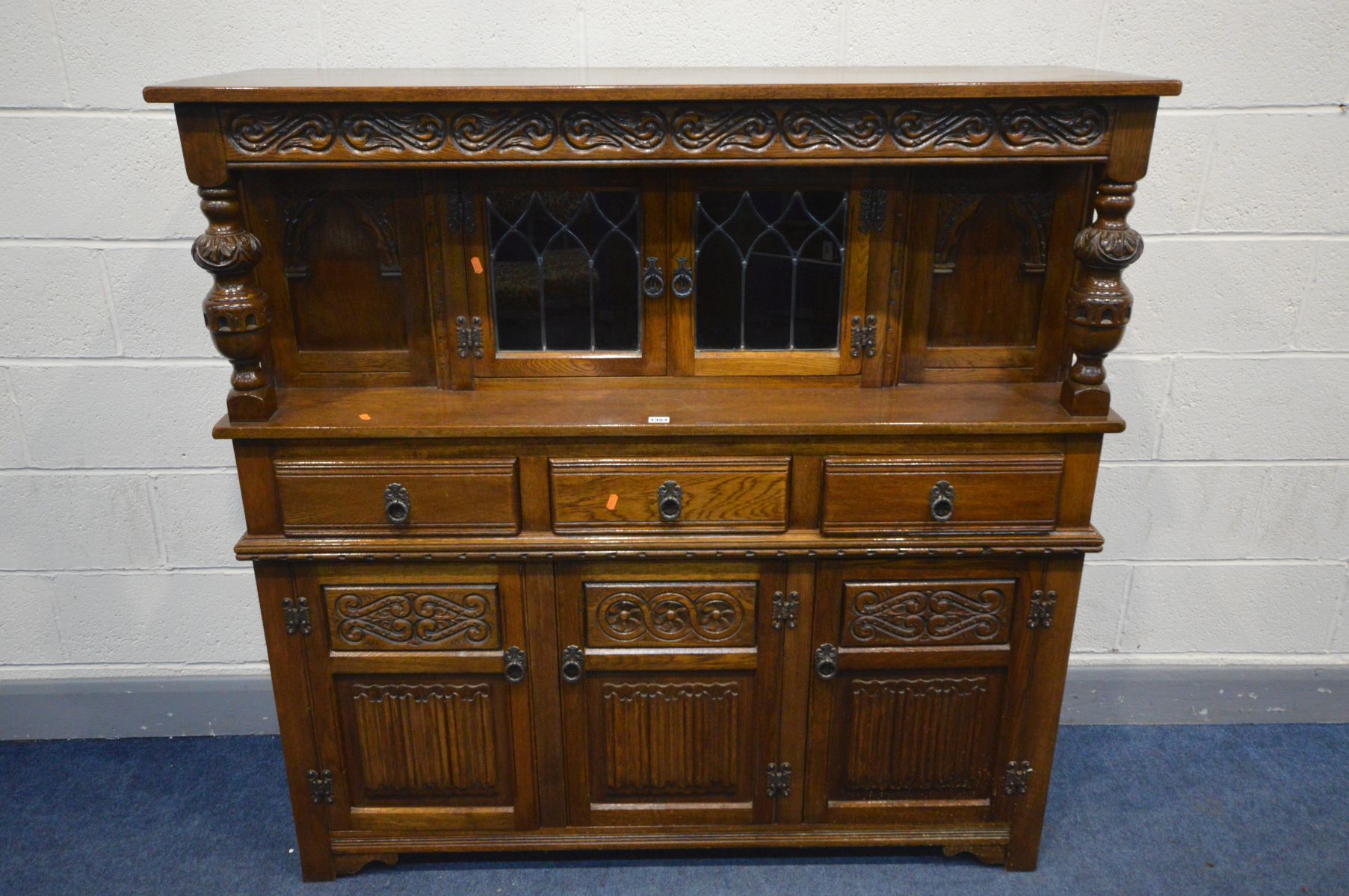 AN OLD CHARM OAK COURT CUPBOARD, with double lead glazed doors above three drawers and three