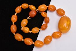 A GRADUATED NATURAL AMBER BEAD NECKLACE, comprising twenty-one barrel shape beads measuring