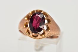 A 9CT GOLD GARNET SIGNET RING, designed with a claw set, oval cut garnet, openwork surround, worn