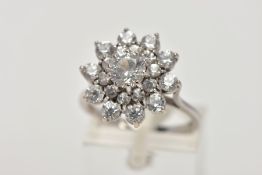 A WHITE METAL SPINEL CLUSTER RING, slightly raised, large flower shape cluster, set with circular