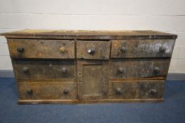 A 19TH CENTURY PINE SHOP COUNTER, made up of six assorted drawers, central panelled cupboard door,