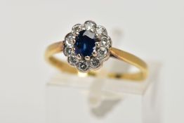 AN 18CT GOLD SAPPHIRE AND DIAMOND CLUSTER RING, the central oval sapphire in a ten claw setting