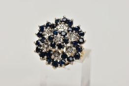 A 9CT GOLD SAPPHIRE AND DIAMOND CLUSTER RING, the tiered cluster claw set with circular blue