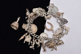 A SILVER CHARM BRACELET AND TWO LOOSE CHARMS, the charm bracelet fitted with twenty-six charms in
