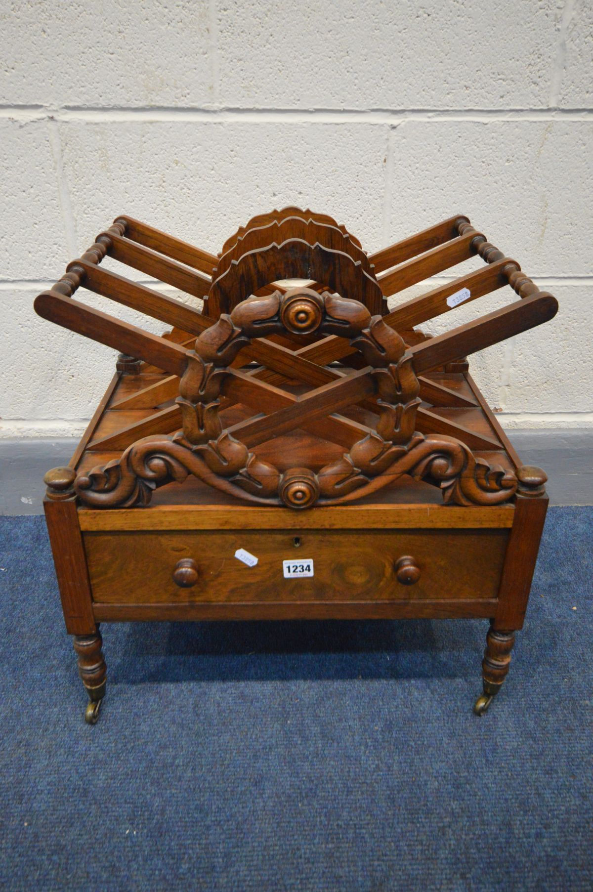 A GEORGE IV ROSEWOOD TRIPLE DIVISION CANTERBURY, the X frame with a carved wreath to the front and