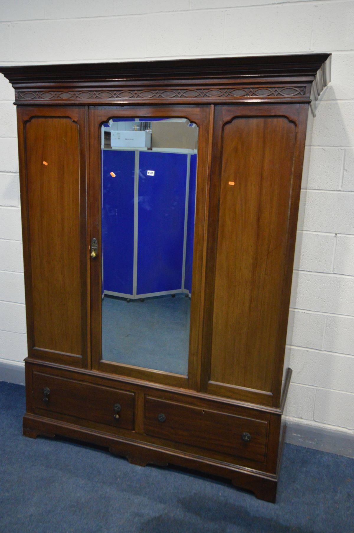 AN EDWARDIAN MAHOGANY MIRRORED SINGLE DOOR WARDROBE, the cornice with blind fretwork, above two