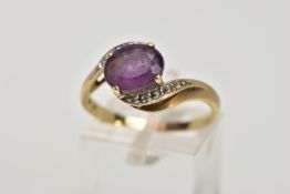 A 9CT GOLD AMETHYST AND DIAMOND CROSS OVER RING, designed with a central oval cut amethyst, single