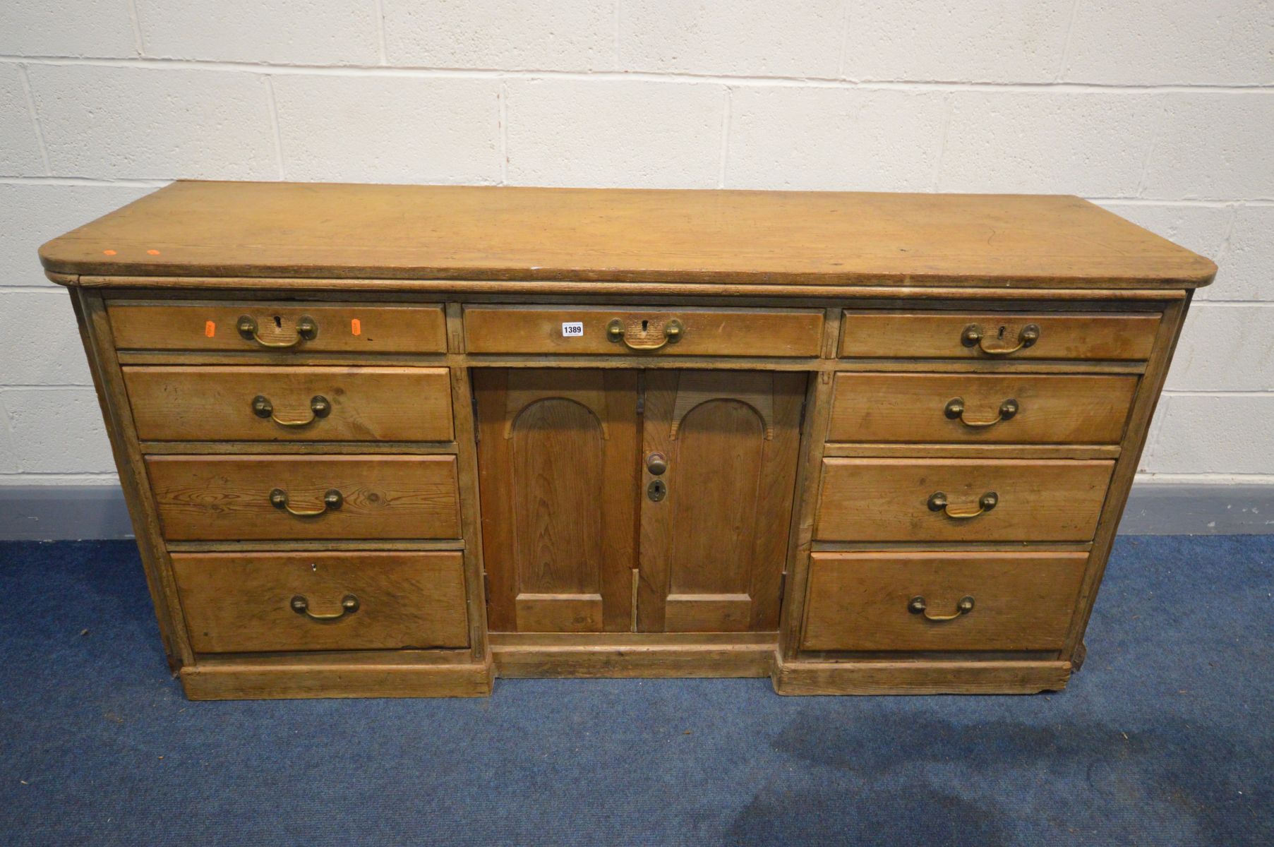 A VICTORIAN PINE SIDEBOARD, nine assorted drawers, flanking double cupboard doors, length 184cm x
