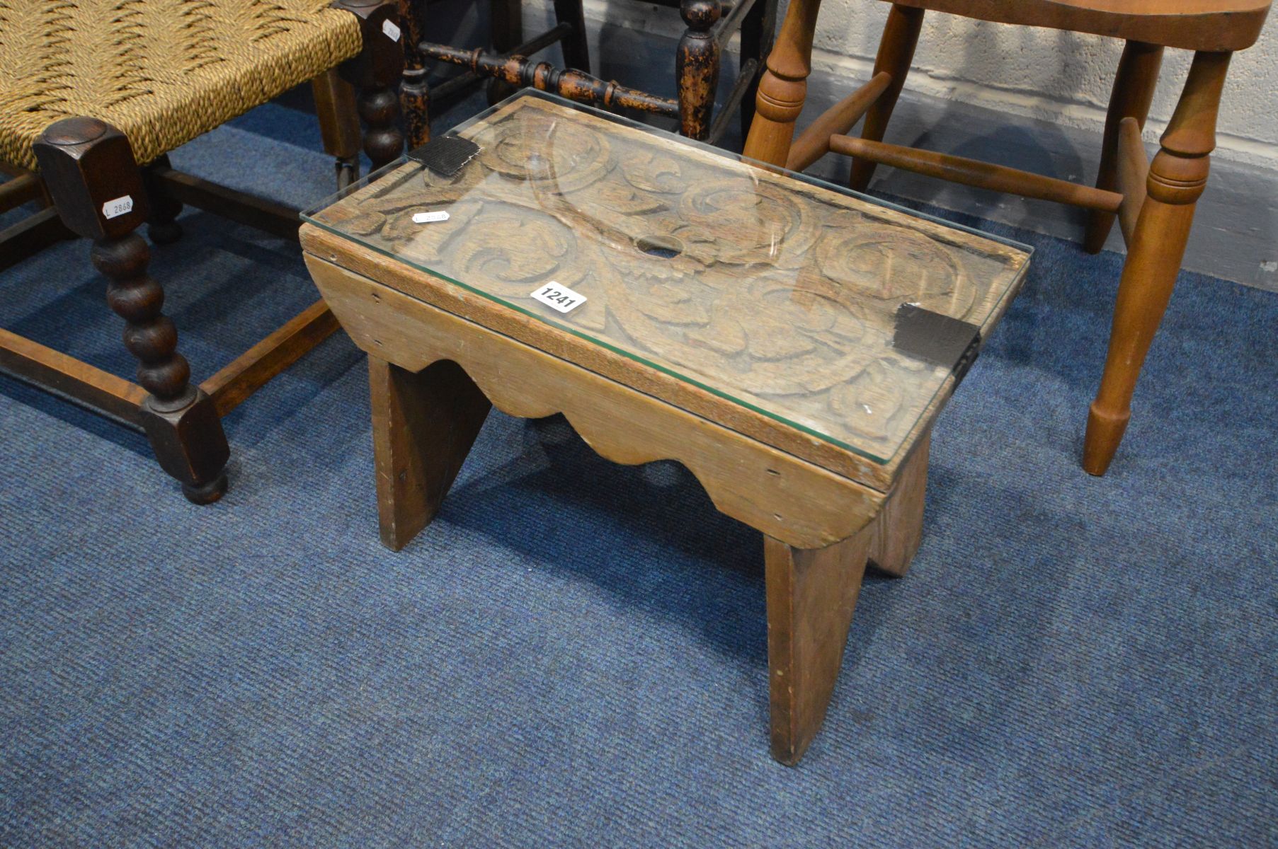 A CARVED OAK STOOL, with a later base and glass panel, along with an oak tea trolley, two chairs and - Image 2 of 3