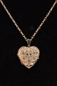 A 9CT GOLD HEART LOCKET PENDANT NECKLACE, the heart locket with an engraved foliate design, opens to