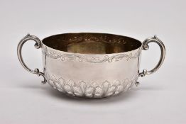 AN EDWARDIAN SILVER DOUBLE HANDLED BOWL, the circular bowl with embossed leaf detail around the base