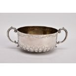 AN EDWARDIAN SILVER DOUBLE HANDLED BOWL, the circular bowl with embossed leaf detail around the base