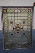A STAINTED GLASS WINDOW, with geometric detailing, including blues, greens, yellows, etc, 87cm x