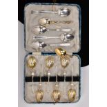 A CASED SET OF SIX SILVER TEASPOONS AND OTHERS, the case set of spoons, each decorated with embossed