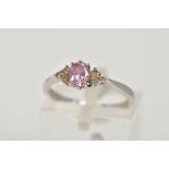 A WHITE METAL CUBIC ZIRCONIA DRESS RING, designed with a central pink oval cut cubic zirconia,