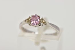 A WHITE METAL CUBIC ZIRCONIA DRESS RING, designed with a central pink oval cut cubic zirconia,