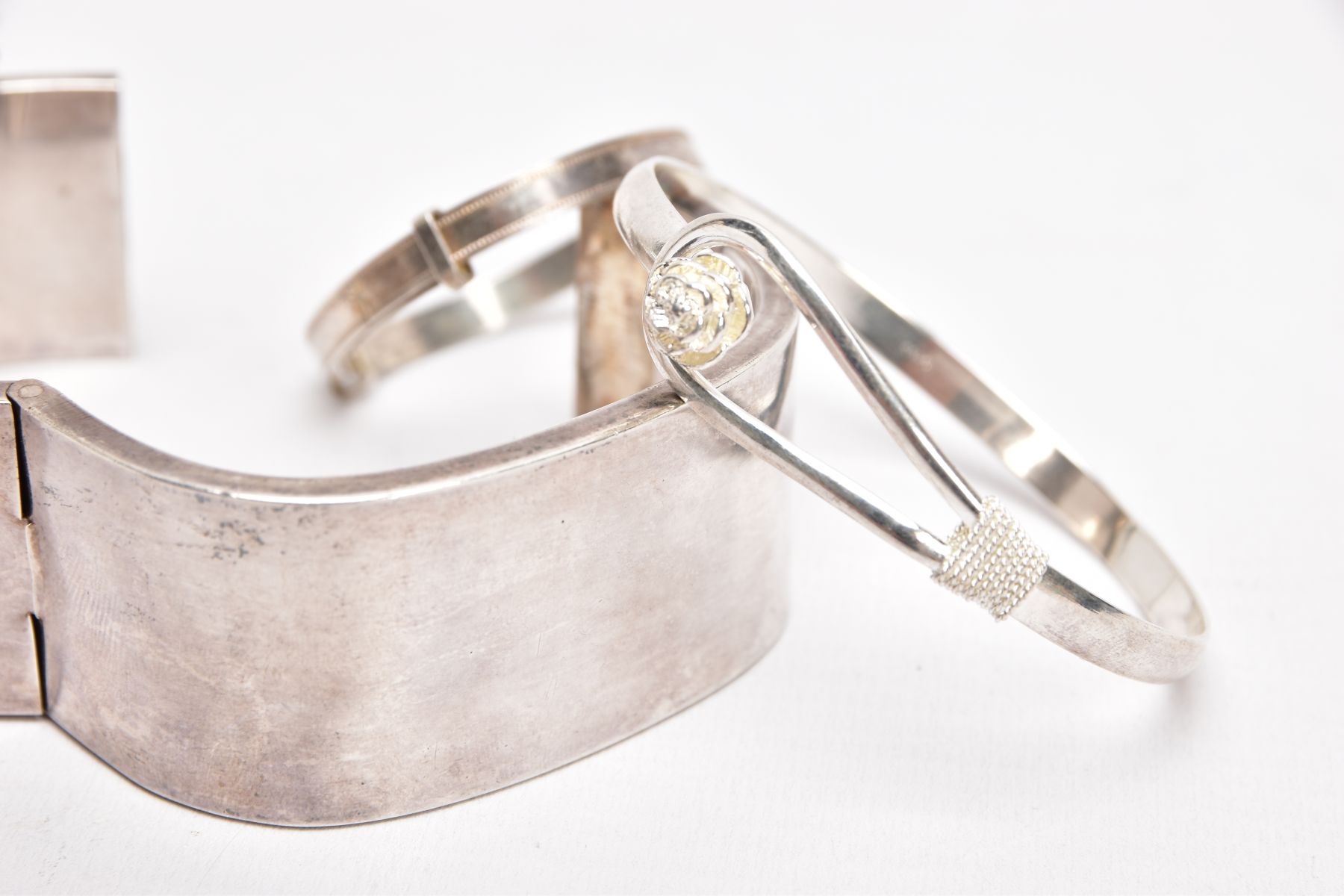FOUR WHITE METAL BANGLES, the first a plain polished square shaped bangle, fitted with a push pin - Image 2 of 3