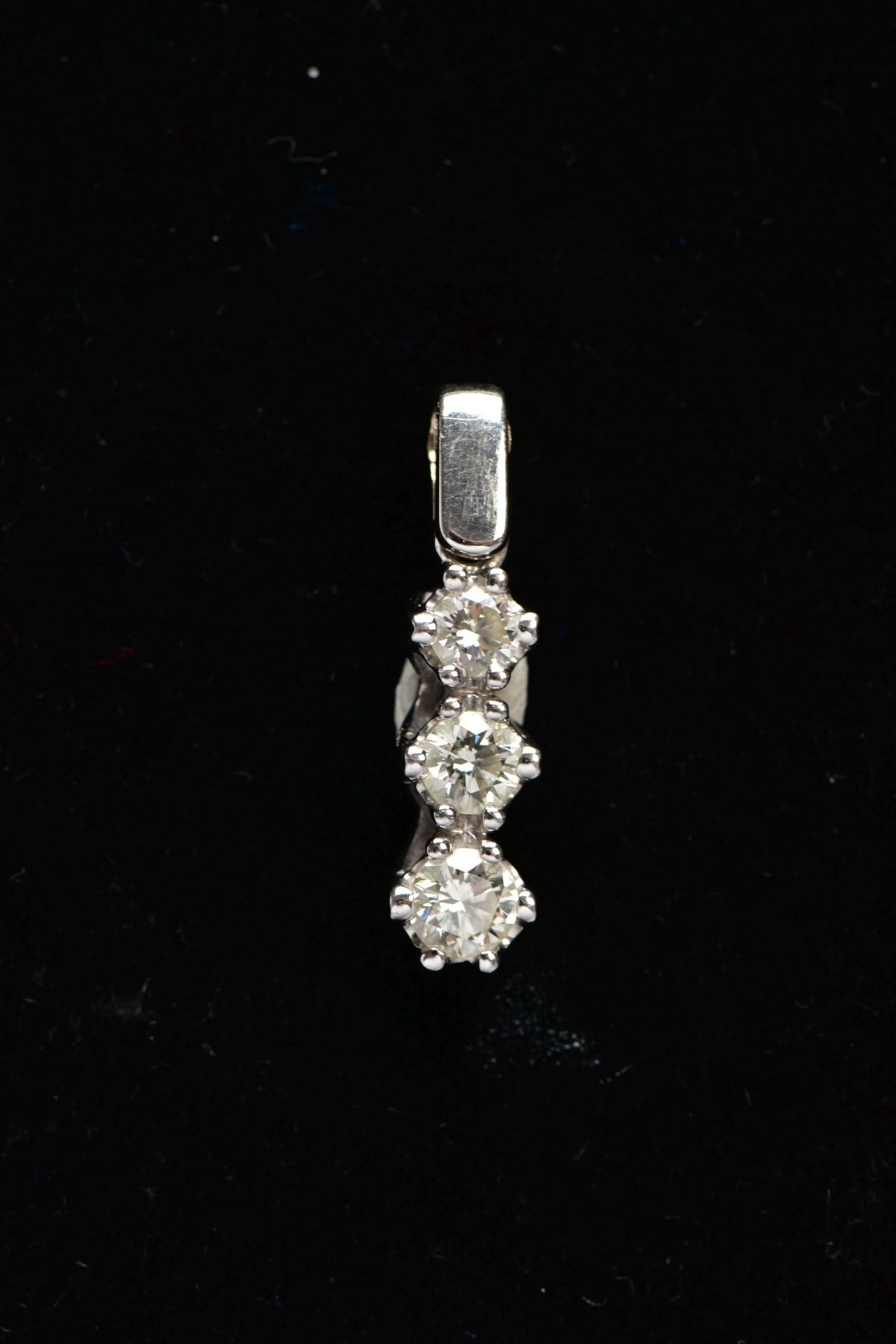 AN 18CT WHITE GOLD, DIAMOND PENDANT, designed with a row of three graduated, claw set, round