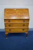 A REPRODUCTION BURR WALNUT BUREAU, with a fitted fall front and two exterior drawers, on cabriole