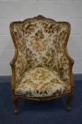 A LOUIS XV STYLE WING BACK ARMCHAIR with a rounded back, width 74cm x depth 71cm x height 111cm (