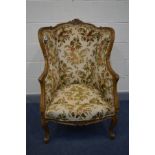 A LOUIS XV STYLE WING BACK ARMCHAIR with a rounded back, width 74cm x depth 71cm x height 111cm (