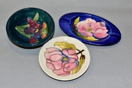 THREE PIECES OF MOORCROFT POTTERY, comprising an oval ashtray, the blue ground with pink magnolia,