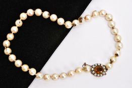 AN EARLY 20TH CENTURY CULTURED PEARL NECKLACE WITH 9CT GOLD GEM SET CLASP, comprising a single row