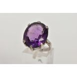 AN 18CT WHITE GOLD AMETHYST RING, the oval amethyst within a six claw setting to the plain band with