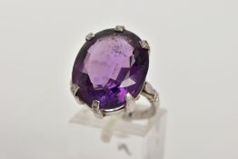 AN 18CT WHITE GOLD AMETHYST RING, the oval amethyst within a six claw setting to the plain band with