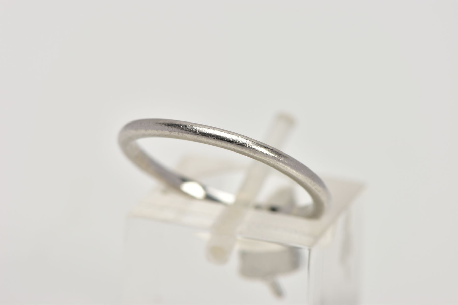 A WHITE METAL WEDDING BAND, plain polished thin band, approximate width 1.3mm, stamped '