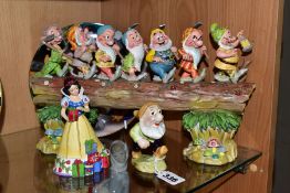 A BESWICK WALT DISNEY LTD FIGURE 'SNEEZY' No 1328 AND THREE MODERN SNOW WHITE AND THE SEVEN DWARFS