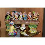 A BESWICK WALT DISNEY LTD FIGURE 'SNEEZY' No 1328 AND THREE MODERN SNOW WHITE AND THE SEVEN DWARFS