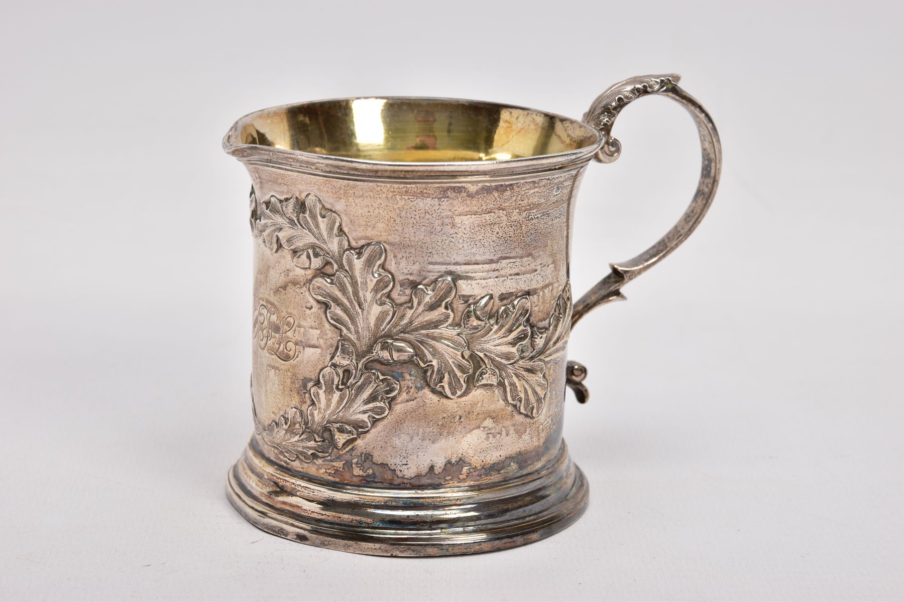 AN EARLY VICTORIAN SILVER CREAM JUG, with embossed acorn leaves scattered with acorns gathered in
