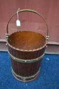 A COOPERED EFFECT AND BRASS BANDED BUCKET, with a brass handle, diameter 31cm x height 36cm (the