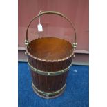 A COOPERED EFFECT AND BRASS BANDED BUCKET, with a brass handle, diameter 31cm x height 36cm (the