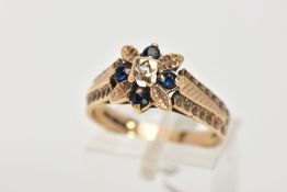 A 9CT GOLD SAPPHIRE AND DIAMOND CLUSTER RING, of a floral design, set with a central single cut