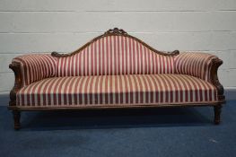A LATE VICTORIAN WALNUT SOFA, with a wavy back, and scrolled armrests, on fluted front legs,