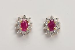 A PAIR OF 9CT GOLD RUBY AND DIAMOND CLUSTER EARRINGS, each designed with an oval cut ruby, within